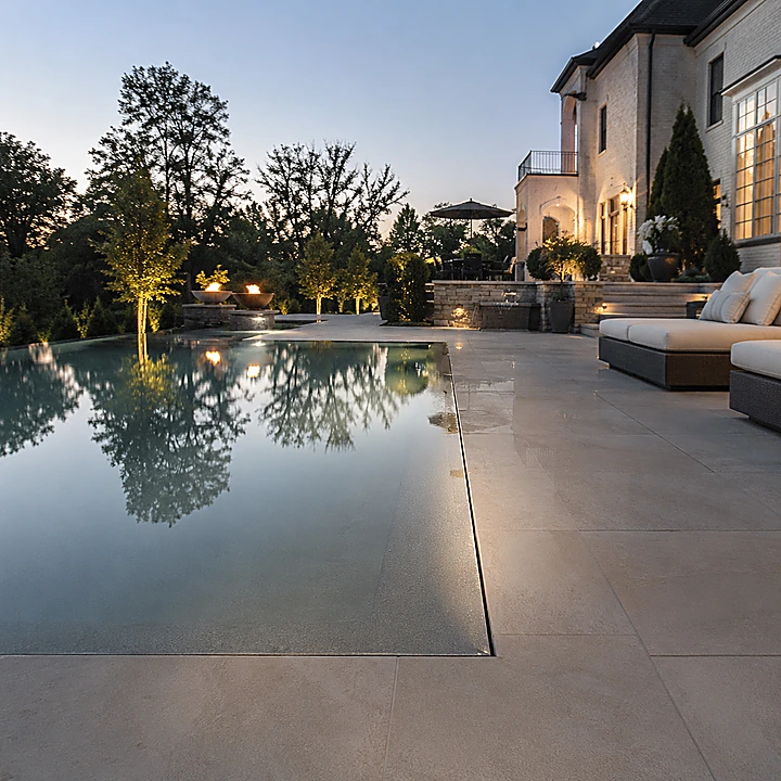 AM Developers LLC built a zero-edge pool deck with perimeter overflow, stone pavers, and luxury outdoor living in Reston, VA