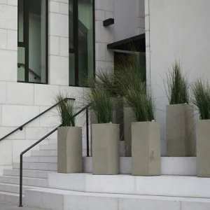 Architectural concrete planter boxes with ornamental grasses installed along commercial masonry stairs by AM Developers LLC near Georgetown Waterfront Park in Washington DC.